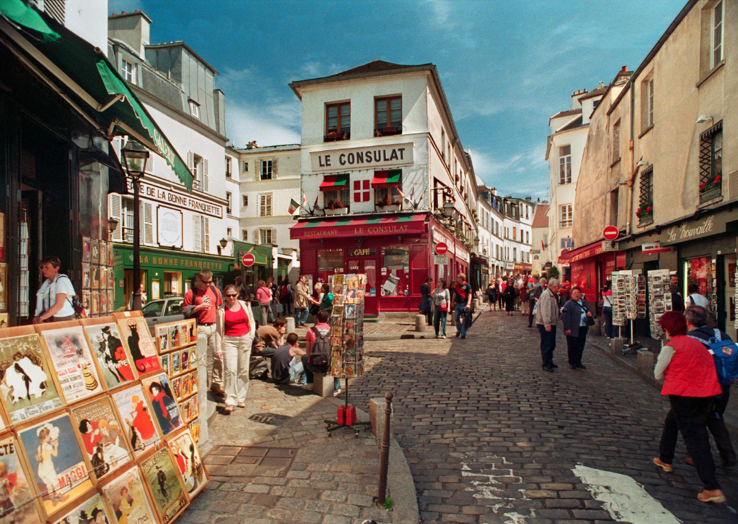 A picturesque street scene in Montmartre, Paris, a district known for its artistic history, charming cafés, and cobblestone streets. 