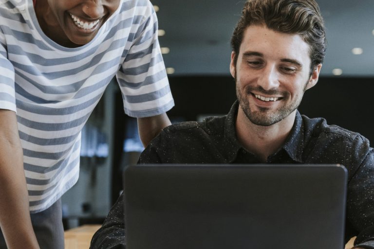 Two people reviewing information together on a laptop